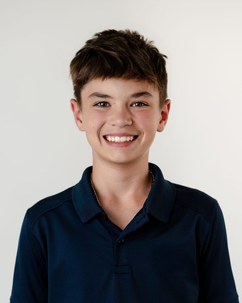 smiling school portrait of a boy in a navy polo, Denver Colorado