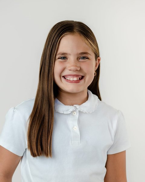smiling school portrait of a girl in a white collared polo, Denver Colorado